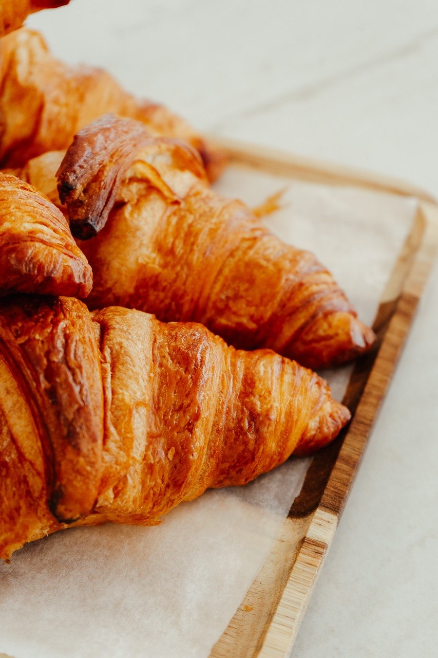 Croissants de Pan Bendito recien horneados en bandeja de madera